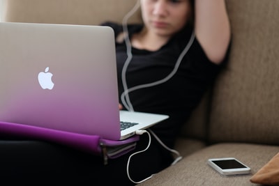 坐在沙发上拿着MacBook Air的女人